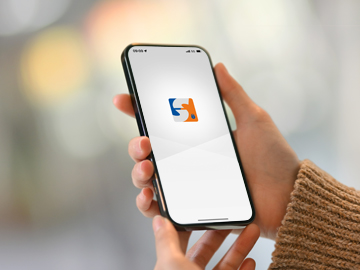 Jemand hält vor verschwommenen Hintergrund ein Smartphone in der Hand.